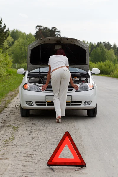 Женщина чинит машину. — стоковое фото