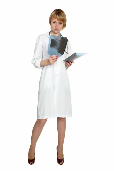 Zamyšlený ženský lékař při pohledu na x-ray snímky. — Stock fotografie