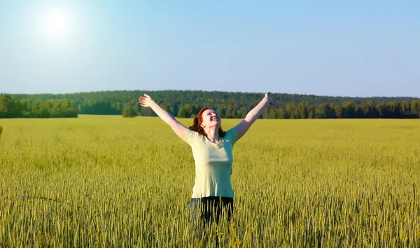 Женщина с распростертыми объятиями в зеленом поле — стоковое фото