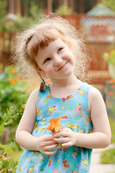 Söt liten flicka med en blomma i handen — Stockfoto