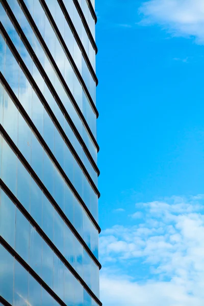 stock image Glass building wall with reflection of clouds