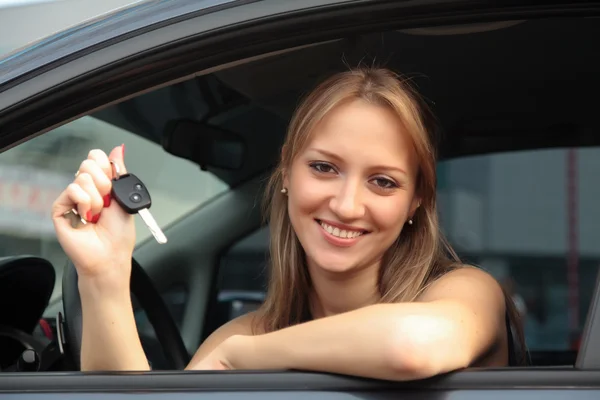 Mulher mostrando a chave de seu carro novo — Fotografia de Stock