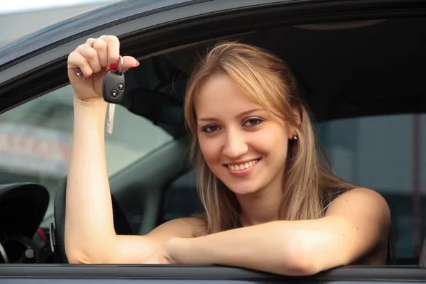 Щаслива жінка показує ключ своєї нової машини — стокове фото