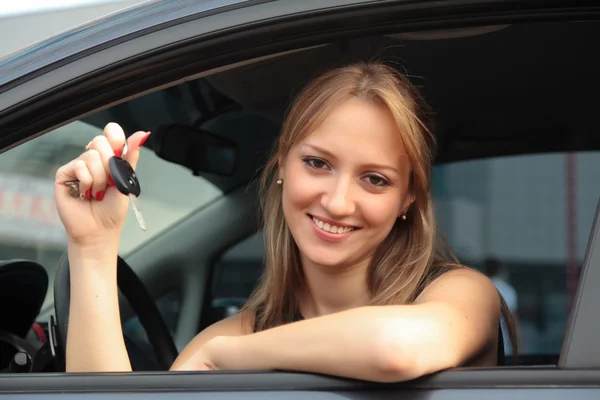 stock image The happy woman showing the key of her new car