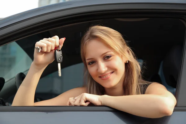 Šťastná žena ukazující klíč od svého nového auta — Stock fotografie