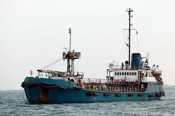 Vieja nave oxidada entrando en un puerto — Foto de Stock