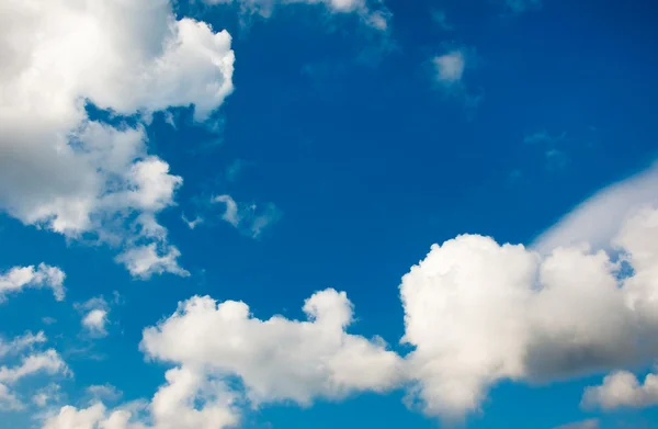 En blå himmel med vita fluffiga moln — Stockfoto