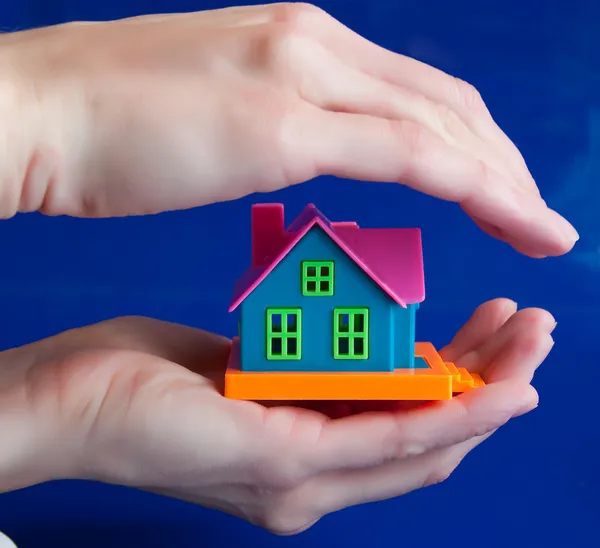 Toy house in human hands - a protection — Stock Photo, Image
