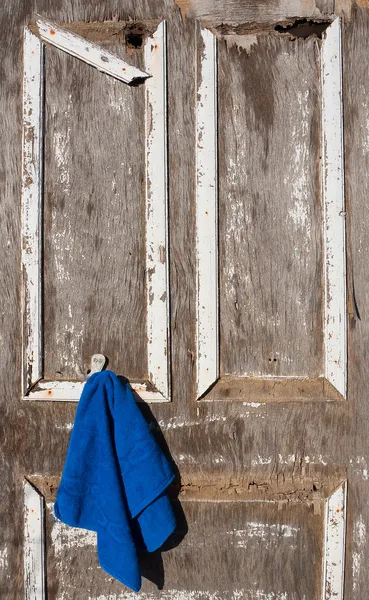 Puerta vieja rota con una toalla azul — Foto de Stock