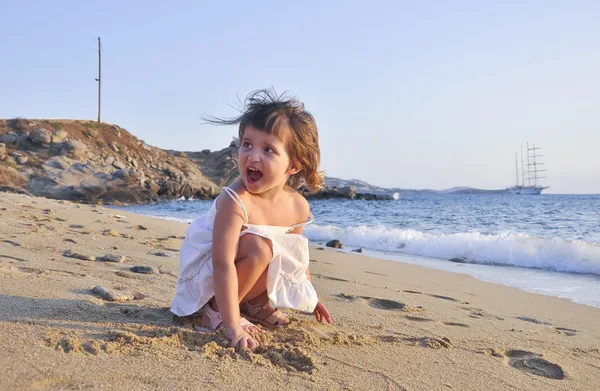 Kis lány a strandon, a fehér ruha — Stock Fotó