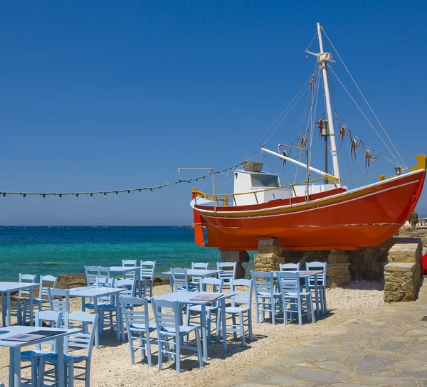Tables in a tavern near the sea and boat — Stock Photo, Image