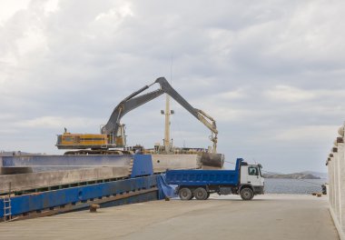 Crane unloads a ship in a truck in port clipart