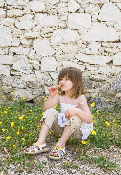A little girl sitting on the ground — Stock Photo, Image