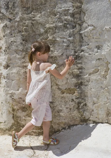 Uma menina de pé na parede — Fotografia de Stock