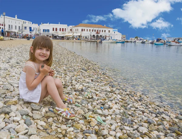 Meisje in witte jurk zittend op strand — Stockfoto