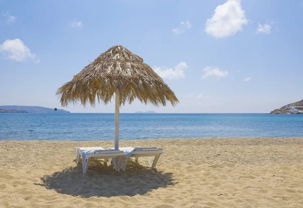 Sockerrör solparasoll och solstolar på stranden — Stockfoto