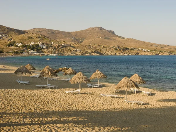 Playa de arena cerca del mar con sombrillas — Foto de Stock