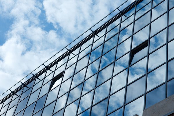 Modern office building with cloud reflections on the glass