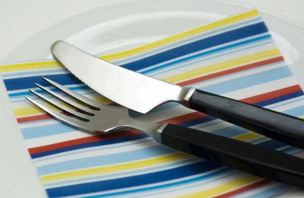 Plug and knife on a plate with a napkin — Stock Photo, Image