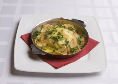 kavrulmuş patates ve peynir altında mersin balığı