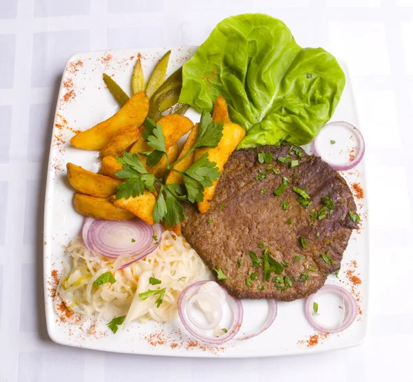 Kalbskotelett mit Salatblättern und gebratener Kartoffel — Stockfoto