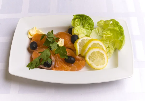 Salmone salato decorato con foglie di insalata, limone — Foto Stock