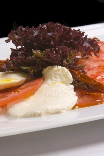 Mozzarella mit Tomaten auf weißem Teller — Stockfoto