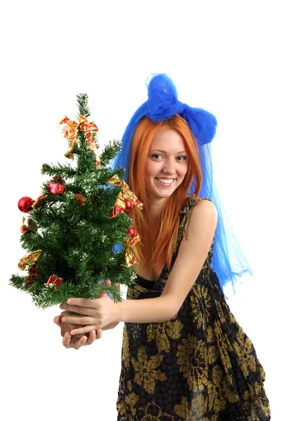 A jovem menina bonita em um vestido mantém uma árvore de Natal em é — Fotografia de Stock