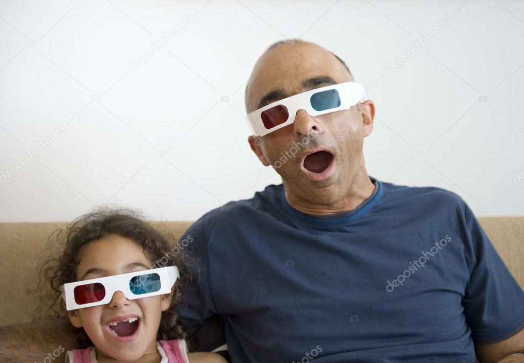 Father and daughter watching television in 3D