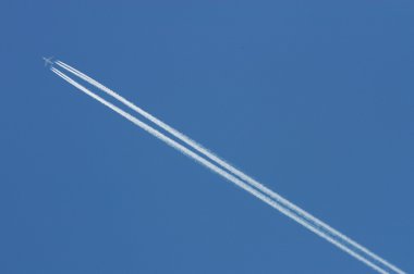 Flying airoplane on the blue sky leaving white l clipart