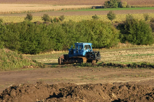 Skidder azul trabalhando no campo, paisagem agro — Fotografia de Stock