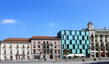 Freedom square in day light with modern and historical buildings clipart
