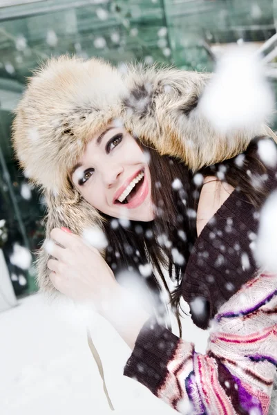 Smiling young woman in falling snow — Stock Photo, Image