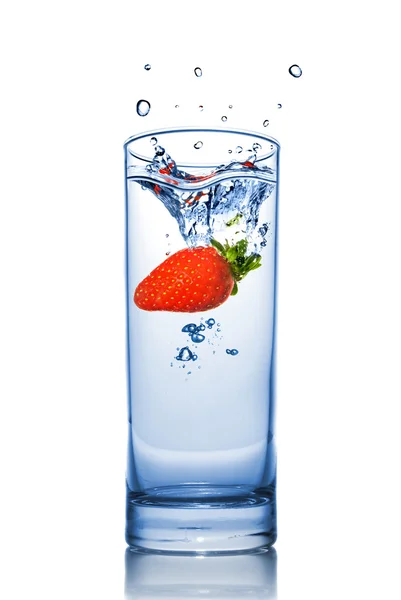 Strawberry dropped into water glass — Stock Photo, Image