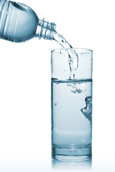 Água que despeja no vidro da garrafa — Fotografia de Stock
