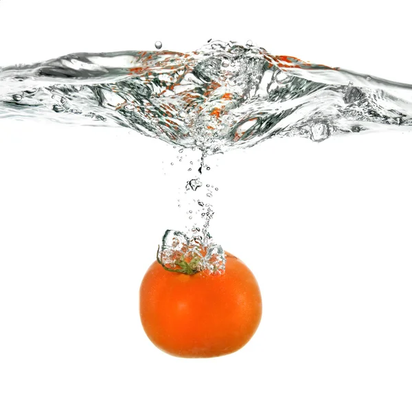 Rode tomaten gedaald in water — Stockfoto