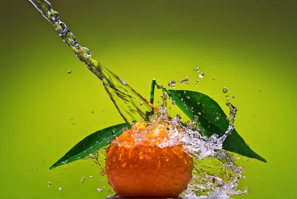 Tangerine met groene bladeren en water — Stockfoto