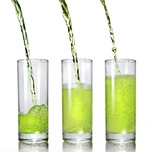 Suco verde derramando em vidro — Fotografia de Stock