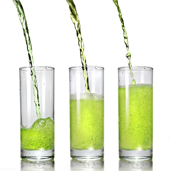 Green juice pouring into glass