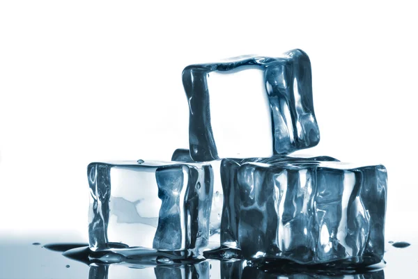 Cubos de gelo com gotas de água no branco — Fotografia de Stock