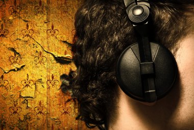 Urban style photo of the man in headphones listening to music clipart