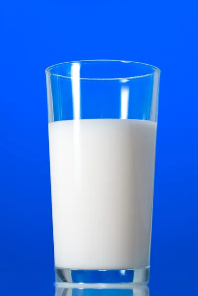 Молоко в стакане, изолированное на голубом — стоковое фото