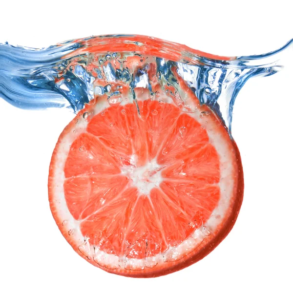 Fresh grapefruit dropped into water — Stock Photo, Image