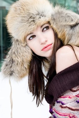 Winter portrait of young woman in fur hat clipart