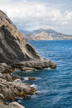 Deniz ve dağlarla kaplı bir manzara.