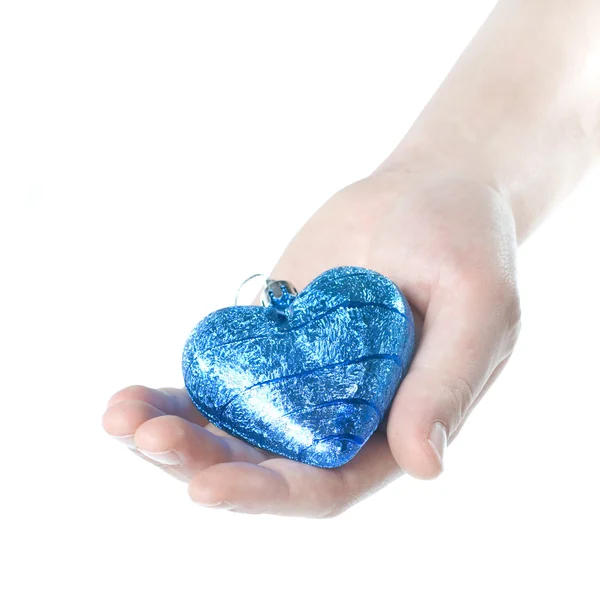 Brazo que sostiene la bola azul de Navidad en forma de corazón — Foto de Stock