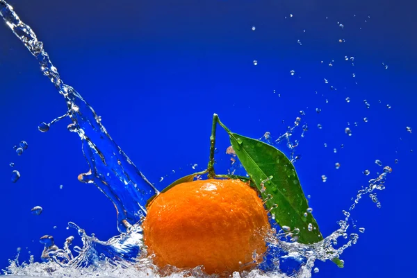 Tangerine aux feuilles vertes et éclaboussures d'eau — Photo