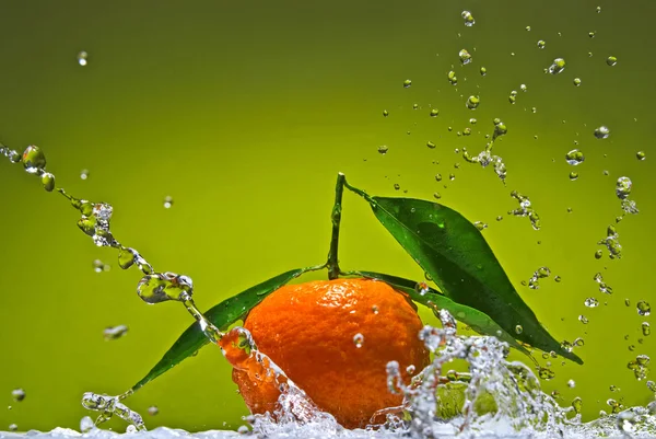 Tangerine met groene bladeren en water splash — Stockfoto