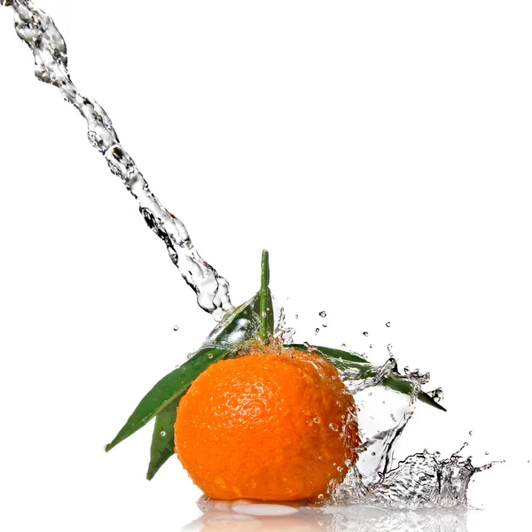 Mandarinky s zelenými listy a stříkající vodě — Stock fotografie
