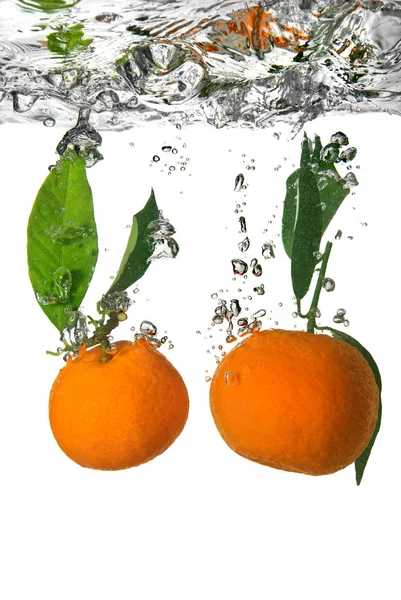 Tangerine впала у воду з бульбашками — стокове фото
